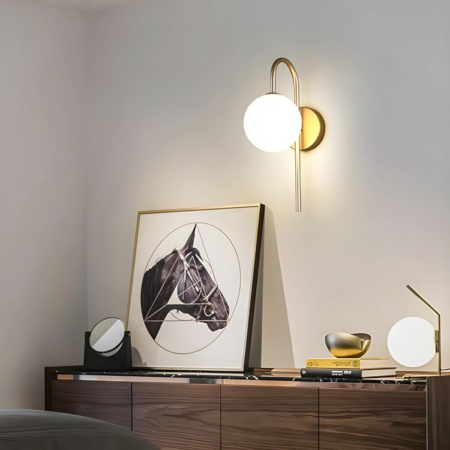 Applique murale couleur doré accrochée au-dessus d'un buffet à côté d'un tableau avec un cheval