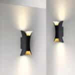 Deux appliques noires avec double éclairage sur un mur blanc.