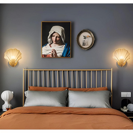 Deux appliques murales en coquillage accrochées à côté d'un cadre dans une chambre