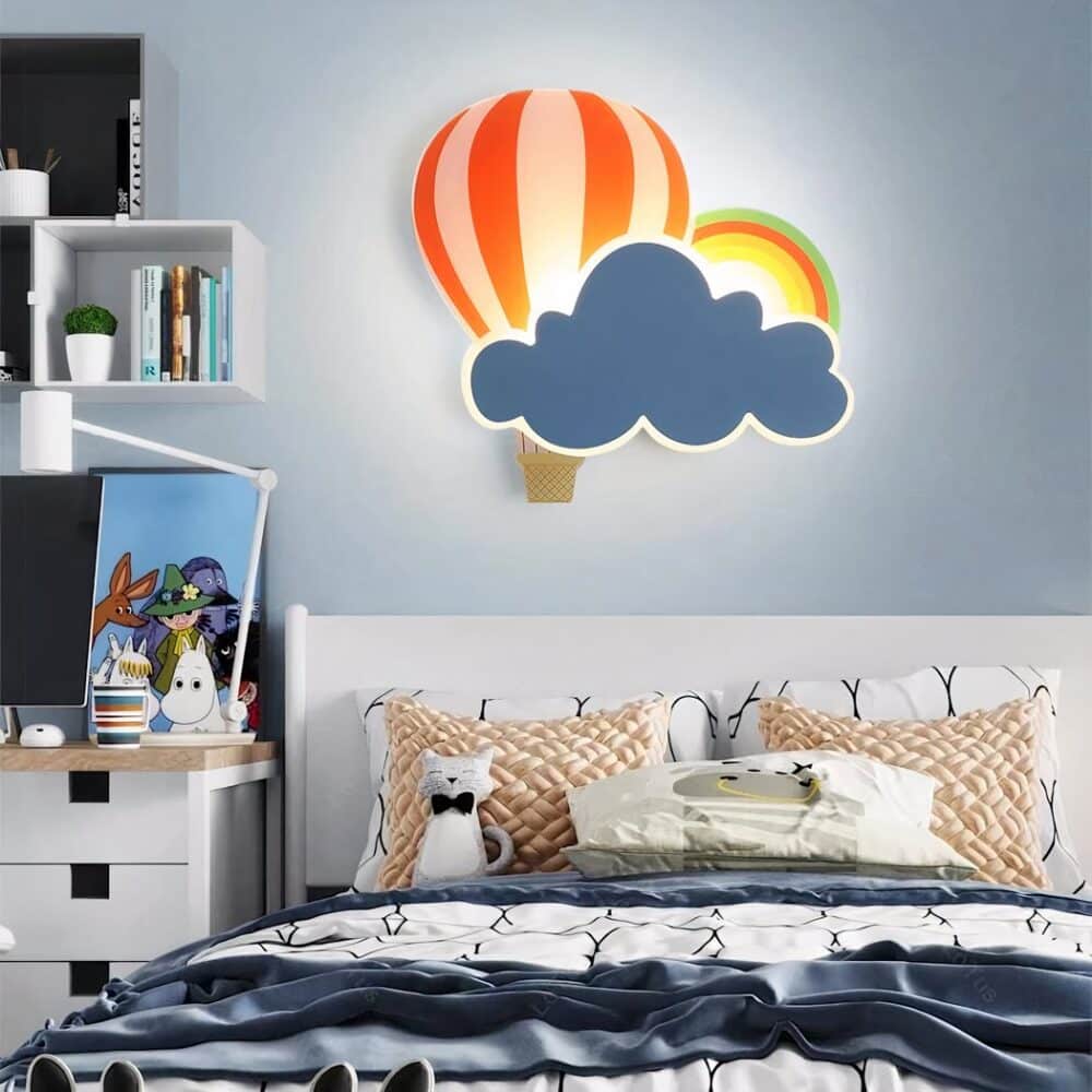 Lampe murale en forme de montgolfière et de nuage accroché à un mur au-dessus d'un lit dans une chambre d'enfant