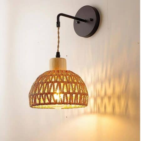 on voit sur un mur gris clair une applique murale en rotin dans le style bohème