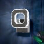 Applique murale carrée creuse argentée avec un effet diamants sur les contours intérieurs et extérieurs. Fixée sur un fond bleu et elle diffuse une lumière froide.