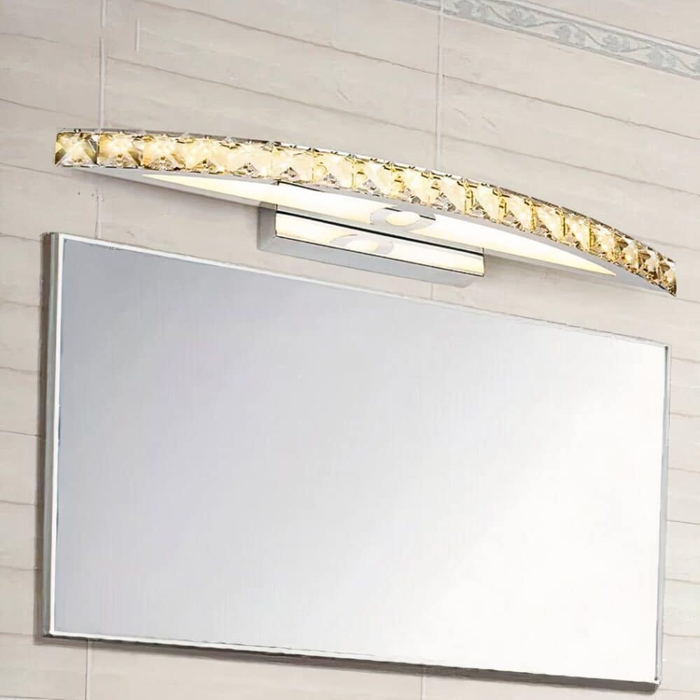 on voit dans une salle de bain au dessus d'un miroir une applique murale de style cristal dorée pour salle de bain