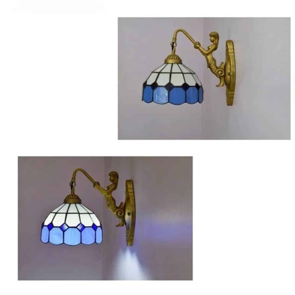 on voit une applique murale de style Tiffany dans les tons bleutés vissée au mur