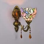 on voit posée sur un mur gris clair une applique murale style Tiffany rose et bleue