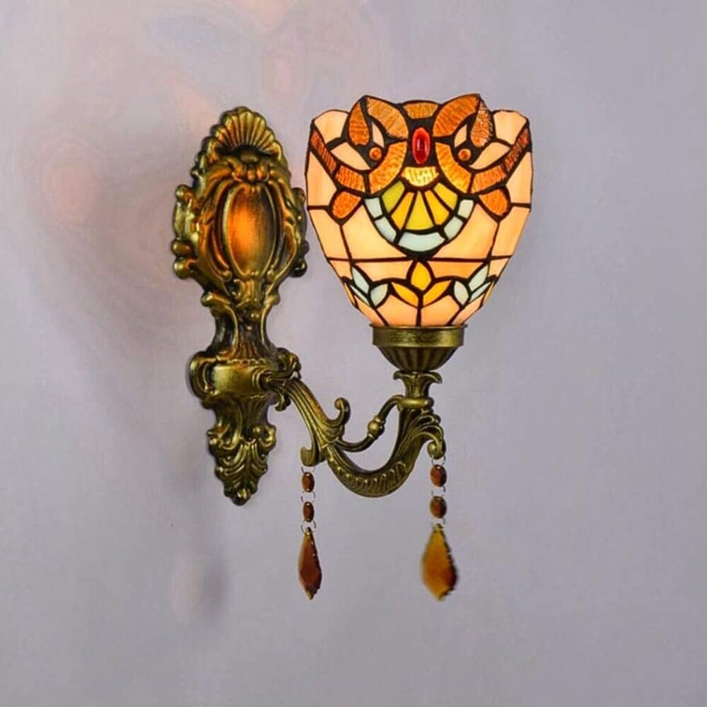 on voit une applique murale style tiffany aux tons orangés posée sur un mur gris clair