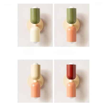 on voit sur un mur gris clair 4 appliques murales de style scandinave avec des couleurs différentes blanc vert rose et rouge