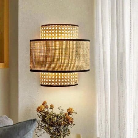 on voit une applique murale en cannage de rotin sur un mur clair de style vintage