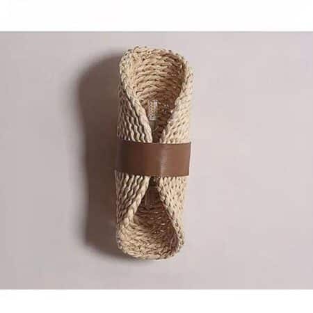 on voit posée contre un mur gris clair une applique murale en chausson style bohème beige claire