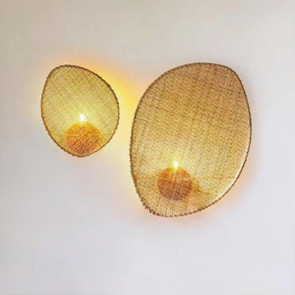 on voit sur un mur gris clair deux appliques murales en cannage de style bohème