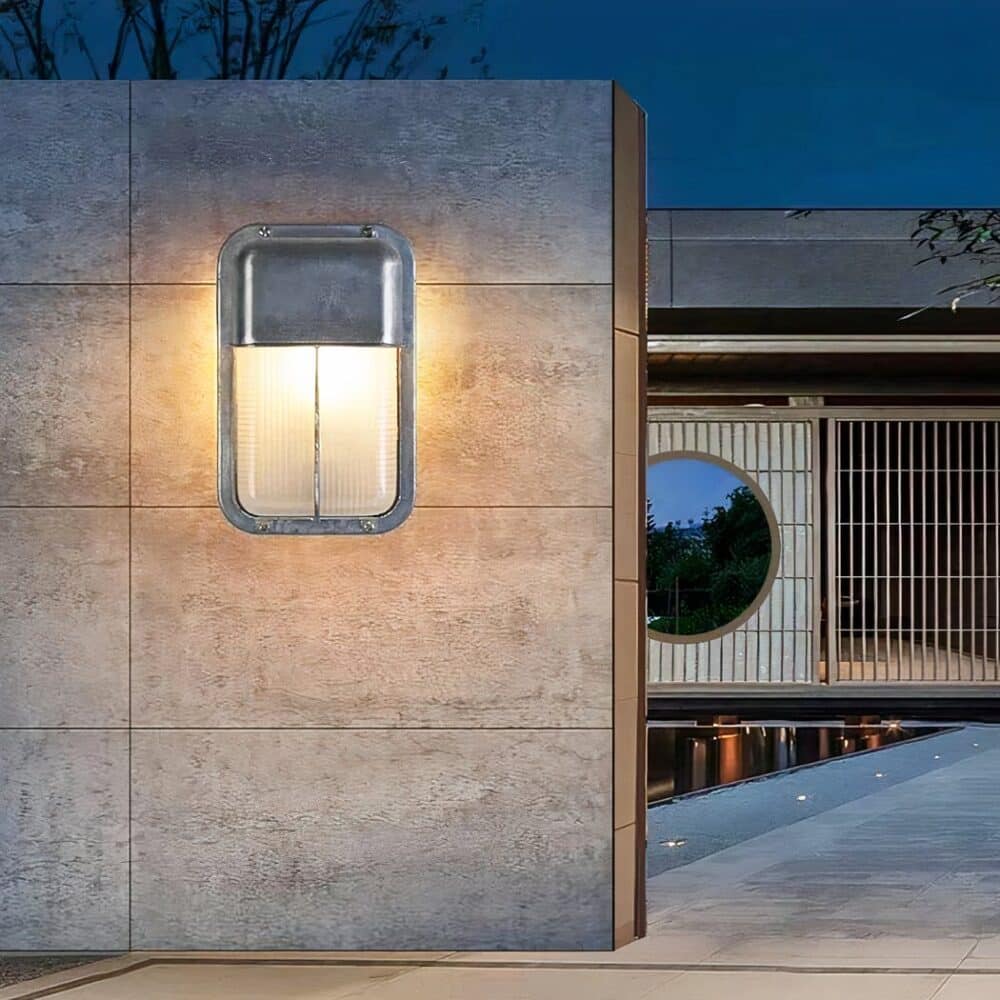 on voit sur un mur extérieur une applique murale rectangulaire grise dan sle style industriel pour intérieur et extérieur