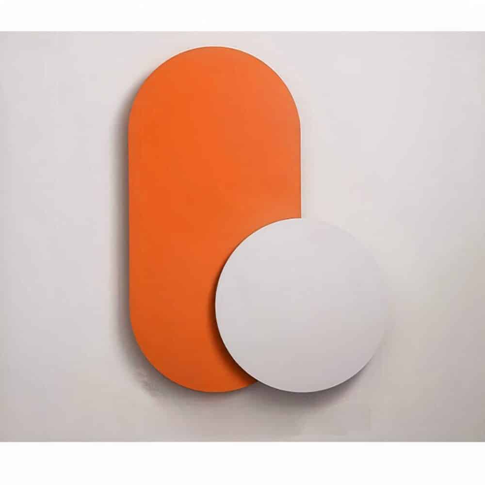 on voit sur un mur clair une applique murale orange dans le style scandinave