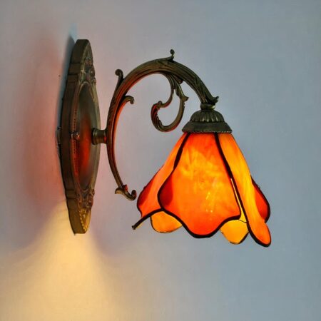 on voit une applique murale en forme de fleur suspendue orange dans le style Tiffany
