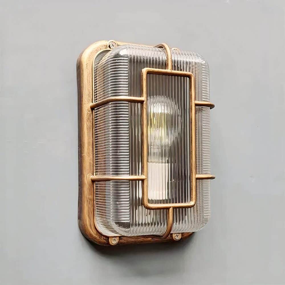 on voit sur un mur gris clair une applique murale vintage avec hublot dans le style industriel pour intérieur et extérieur