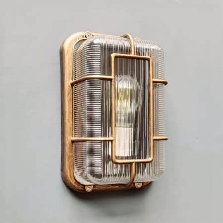 on voit sur un mur gris clair une applique murale vintage avec hublot dans le style industriel pour intérieur et extérieur