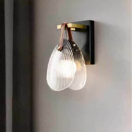 on voit sur un mur gris une applique murale en forme de coquillage en verre