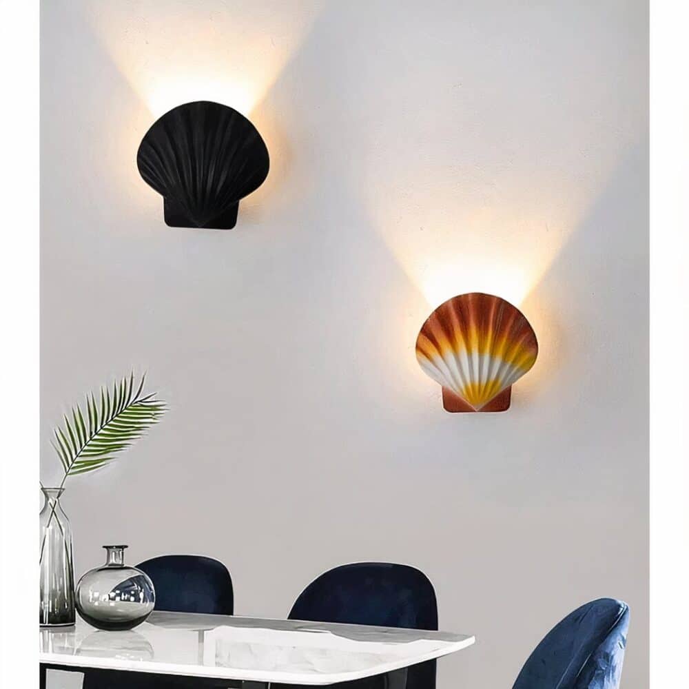 on voit dans un salon aux murs gris deux appliques murales en forme de coquille saint jacques une marron et une noire