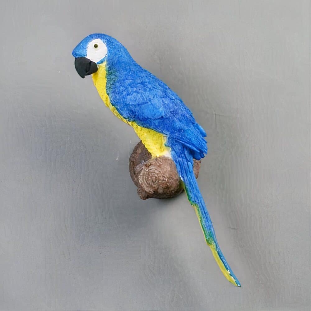 on voit sur un mur gris clair une applique murale en forme de perroquet bleu