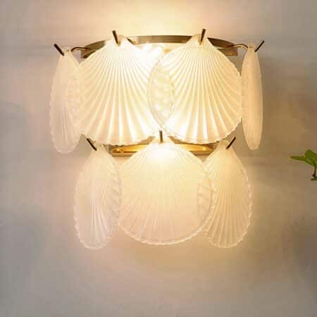 on voit sur un fond clair une applique murale en forme de lustre en coquillage en verre