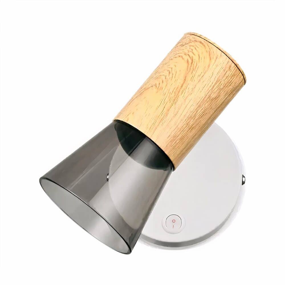 Applique murale liseuse avec socle rond gris et spot couleur bois et extrémité en acrylique. un interrupteur intégré sur le socle. Sur fond blanc.