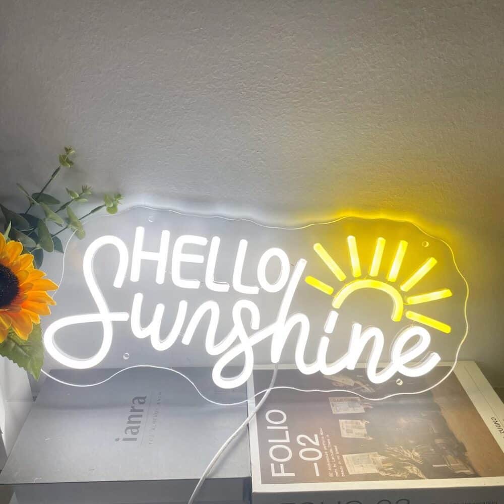 Applique murale néon soleil levant posée sur un meuble et sur fond de mur blanc.