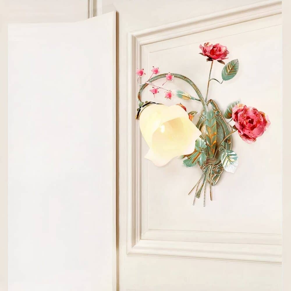 Applique murale rétro en fer forgé et en forme de fleur allumée et fixée sur un mur blanc.