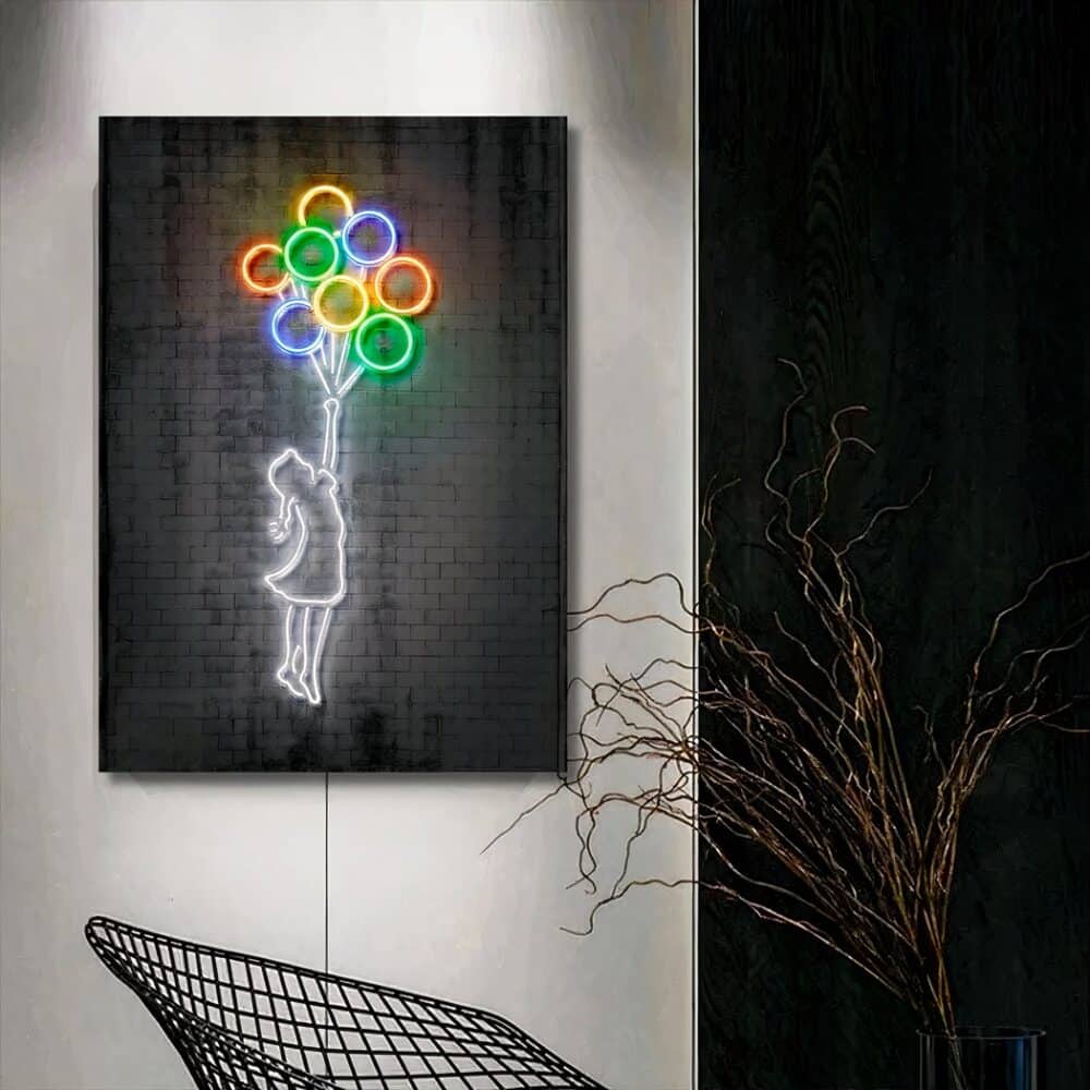 Toile grise avec un motif d'une petite fille avec les contours lumineux blancs tenant dans sa main des ballons dont les contours sont lumineux et colorés. La toile est sur un mur gris clair. La partie de droite est noire avec un branchage devant et un fauteuil style métal.