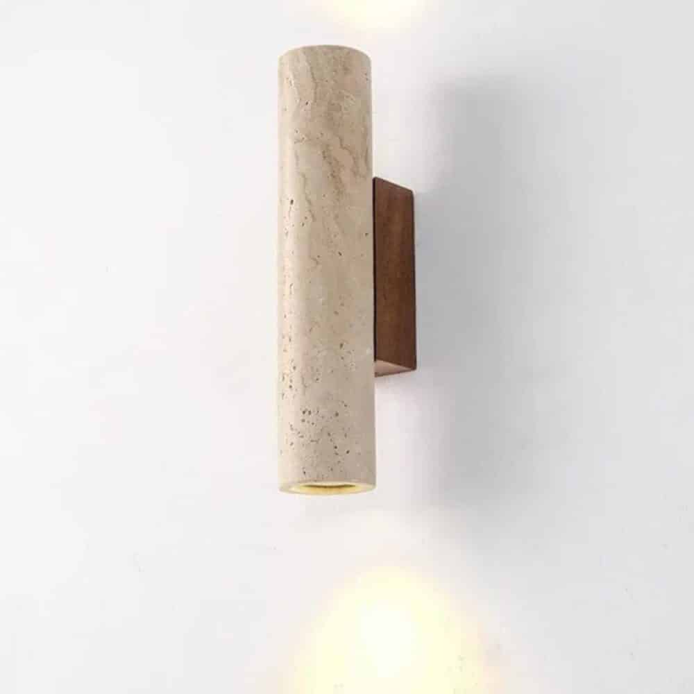 Applique murale japandi beige de forme cylindrique, fixée à un mur gris clair, allumée.